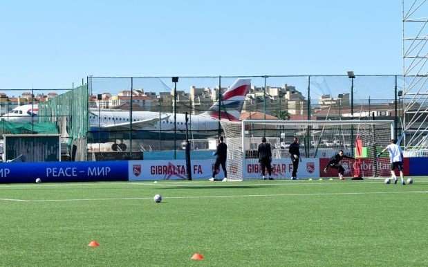 Aeroplani niset nga pista, derisa futbollistët stërviten në stadium