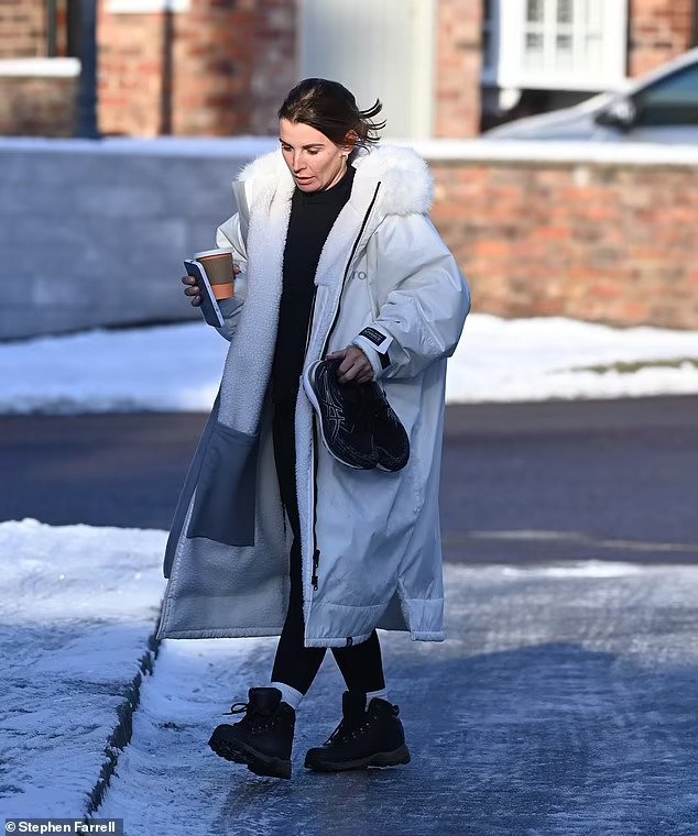 Coleen Rooney joshëse me një pallto të bardhë teksa përballon dëborën përpara stërvitjes së saj në mëngjes