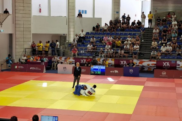 ​Cena fiton luftën e parë, në çerekfinale ballafaqohet me xhudistin serb